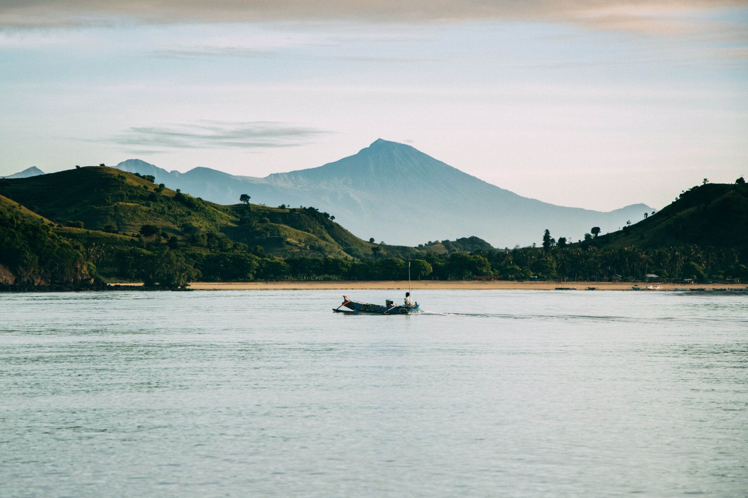 A serene boat ride with a stunning view of Mount Rinjani at West Nusa Tenggara, Indonesia.
